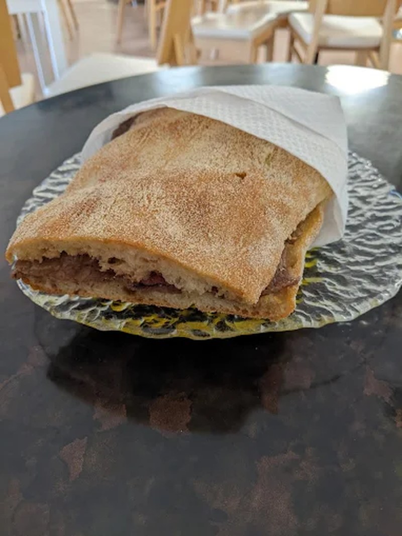 Focaccia farcita servita al tavolo per il pranzo veloce a Nuoro